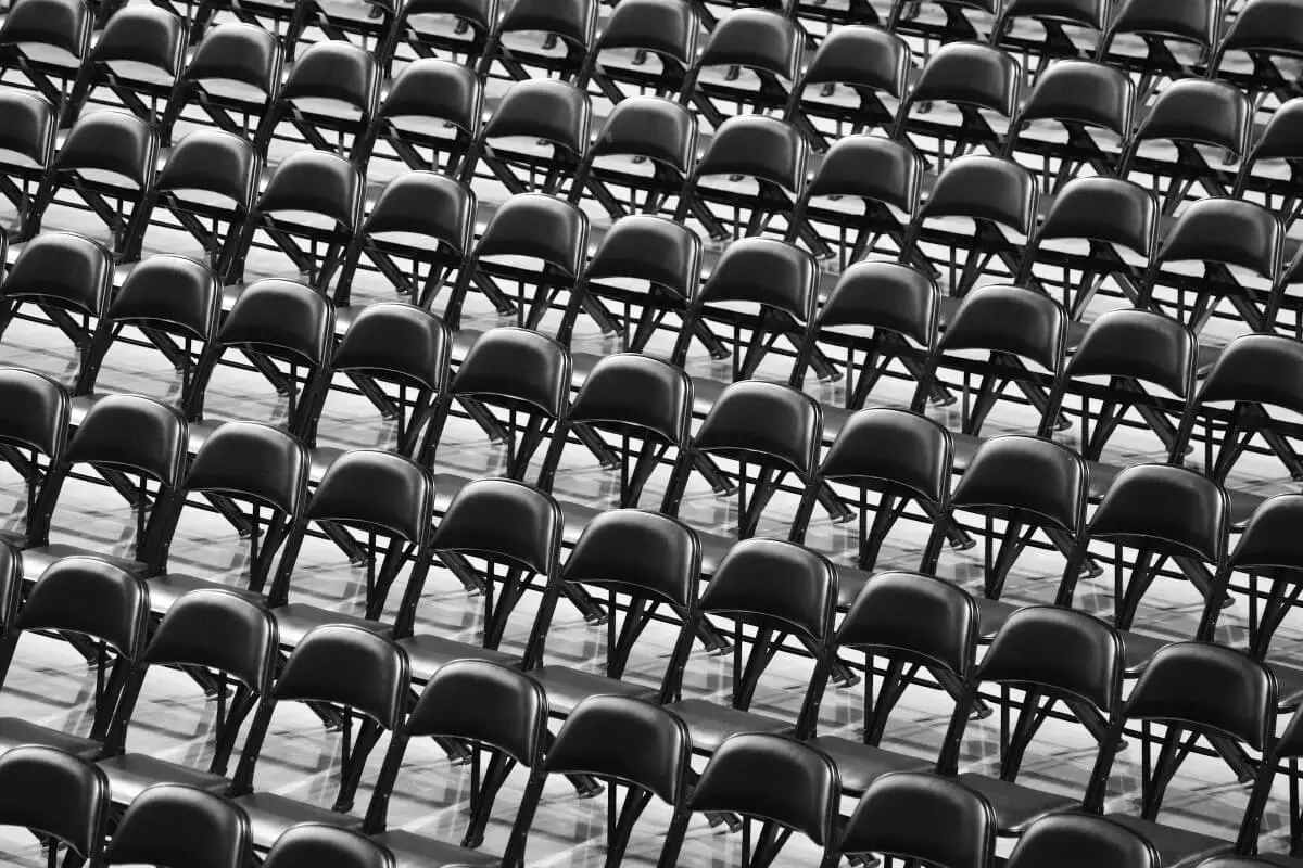Empty folding metal chairs, indicating Japan's toxic work culture